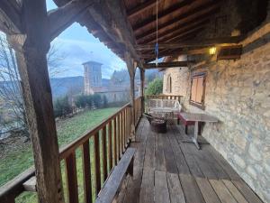 a wooden porch with a bench and a view of a castle at Le balcon de Vernay in Vernay