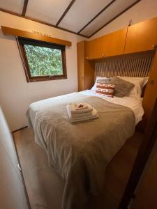 a bedroom with a large bed with towels on it at Chalet aan de Rotte in Rotterdam