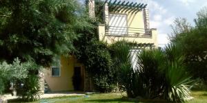 a yellow house with a balcony and some plants at Seaside Green Villa in Karianí