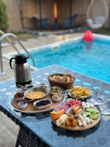 a tray of food on a table next to a pool at Vadi Karavan Otel in Buca