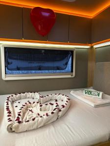 a bed in a room with a heart above it at Vadi Karavan Otel in Buca