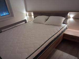 a bed with two pillows on it in a room at Onix 1 in Soko Banja