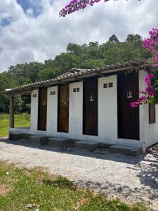 a row of wooden doors on a building at Camping Fazenda Serramar in Palhoça
