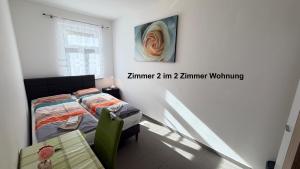 a bedroom with a bed and a painting on the wall at Kim Ferienwohnung A in Sömmerda