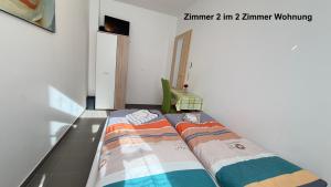 a bed in a room with two pillows on it at Kim Ferienwohnung A in Sömmerda +4 photos