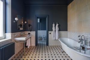 a bathroom with a tub and a sink at Lion's Castle Hotel in Lviv +105 photos