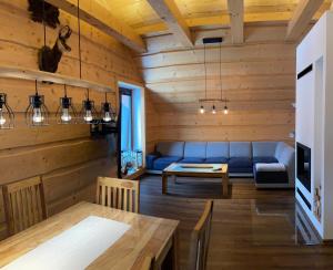 a living room with a blue couch and a table at Apartmánový Dom Terchová in Terchová
