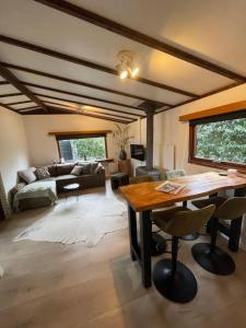 a living room with a table and a couch at Chalet aan de Rotte in Rotterdam