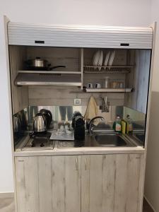 a kitchen with a sink and a stove at Ifestia Hotel in Kamari
