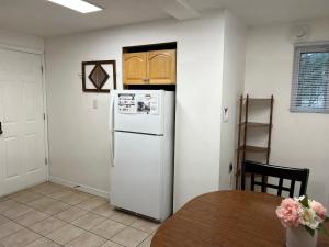 a kitchen with a white refrigerator and a table at Private 1BR with Parking & Laundry Near Boston in Everett