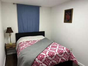 a bedroom with a bed with a red and white blanket at Private 1BR with Parking & Laundry Near Boston in Everett +3 photos