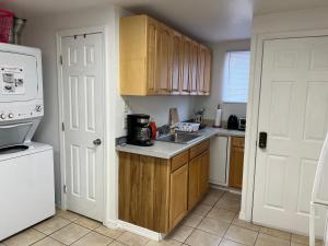 a kitchen with wooden cabinets and a sink in it at Private 1BR with Parking & Laundry Near Boston in Everett