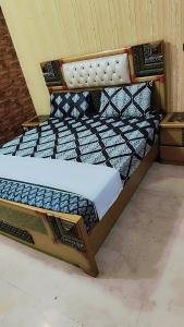 a small bed in a room next to at Hotel Decent Lodge in Multan