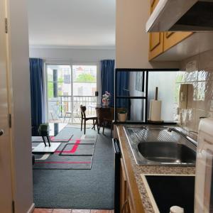 a kitchen with a sink and a living room at Villa on Grafton in Cairns