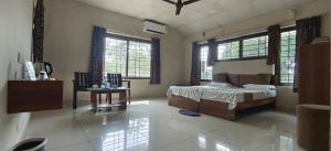 a bedroom with a bed in a room with windows at Sugamya Farm Guesthouse in Sāgar +11 photos