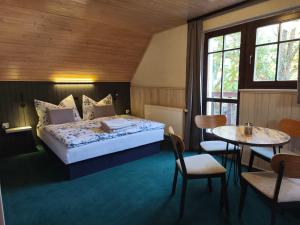 a bedroom with a bed and a table and chairs at Pension DORO in Černý Dŭl