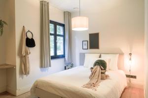 ein Schlafzimmer mit einem Bett, auf dem ein Hut liegt in der Unterkunft Weynhoven in Brecht