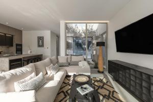 a living room with a couch and a flat screen tv at Lagoon Residence 56 Deluxe in Óbidos