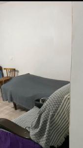 a bedroom with a bed with a blanket on it at Old Guesthouse Tsikhisdziri in Tsikhisdziri
