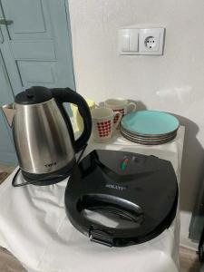 a tea kettle on a counter with plates and cups at Old Guesthouse Tsikhisdziri in Tsikhisdziri