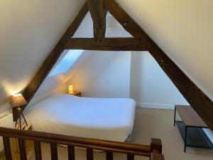 a bedroom with a white bed in the attic at Charmy in Granville +32 photos