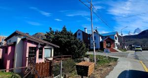 a row of houses on a street with mountains in the background at Casa Pier Giorgio in El Chalten