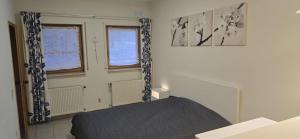 a room with a bed and two windows at Ferienwohnung PfalzRide in Annweiler am Trifels