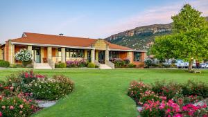 ein Haus mit einem Vorgarten, vor dem Blumen wachsen in der Unterkunft Botleng Guest House in Maseru