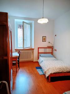 a bedroom with two beds and a table and a window at B&B Leon d'Oro in Pusiano