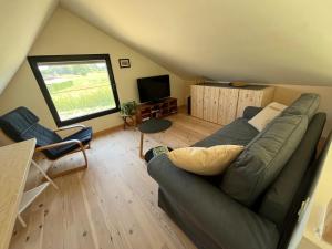a living room with a couch and a television at Bellefleur Cottage in Herent