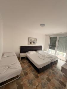 a bedroom with two beds and a window at Apartaments Shengjin with sea view in Shëngjin +48 photos