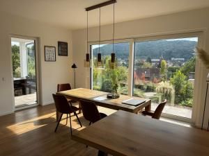 a dining room with a table and chairs and a large window at Haus Sonnenhang in Hauenstein