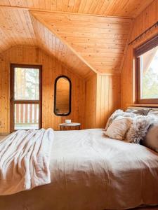 a bedroom with a large bed in a wooden room at Domek u Ewy in Rydzewo