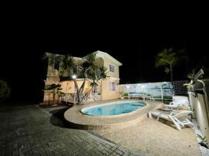 a house with a swimming pool at night at Villa kartner in Albion