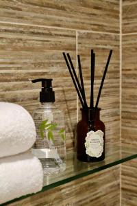 a glass shelf with a bottle of soap and some towels at The Dove in Knook +10 photos