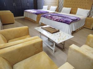 a room with two beds and a table and chairs at Grand Orchard One Hotel in Lahore +41 photos
