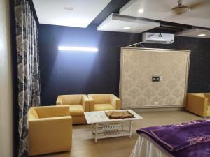 a waiting room with yellow chairs and a table at Grand Orchard One Hotel in Lahore