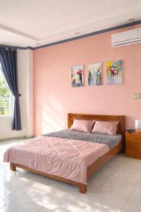 a bedroom with a bed and paintings on the wall at PINK Hotel Cần Thơ in Can Tho +42 photos