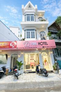 a pink hotel with scooters parked in front of it at PINK Hotel Cần Thơ in Can Tho