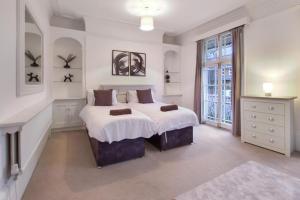 a white bedroom with a large bed and a window at town house in Northampton