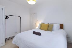 a bedroom with a large white bed with a spotlight at town house in Northampton +11 photos