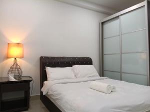 a bedroom with a white bed with a lamp and a window at peacehome 13a in Cyberjaya +49 photos