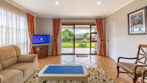 ein Wohnzimmer mit Sofa und Fernseher in der Unterkunft Botleng Guest House in Maseru