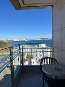 a balcony with a table and a view of the ocean at Honor Appart Hotel in Fnidek