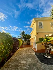 a driveway leading to a yellow house at Villa kartner in Albion