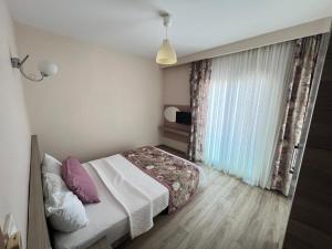 a small bedroom with a bed and a window at Marina Suite Otel in Silifke