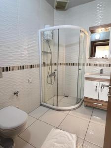 a bathroom with a shower and a toilet and a sink at Marina Suite Otel in Silifke +11 photos