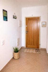 a hallway with a wooden door and a potted plant at Casa Da luz 5 - sea view 2 bedrooms apt , beach & swimming-pool in Luz +28 photos