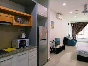 a kitchen with a refrigerator and a living room at peacehome 13a in Cyberjaya