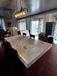 a large marble table in a dining room with chairs at Brandons Beach Resort in Inayauan